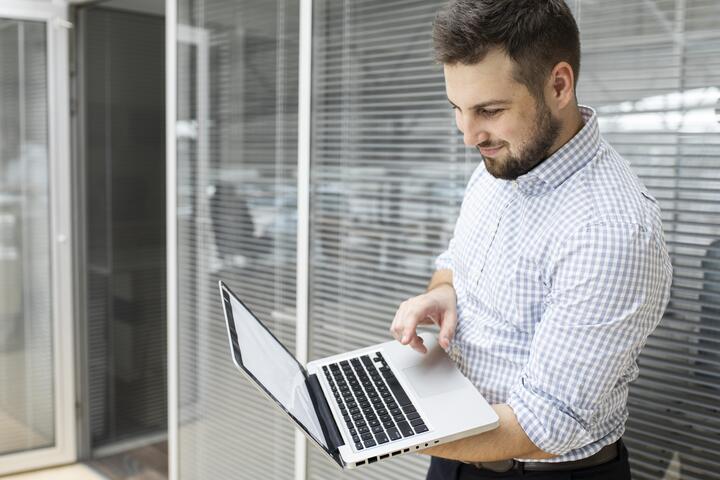 CRM para ópticas. Homem segurando um notebook.